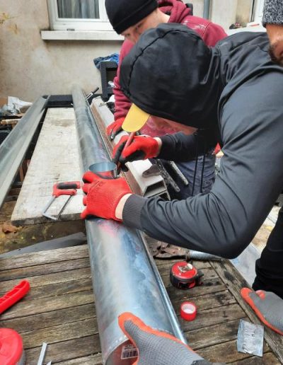 Pose d'une gouttière en zinc par l'équipe de Cotos Batiment